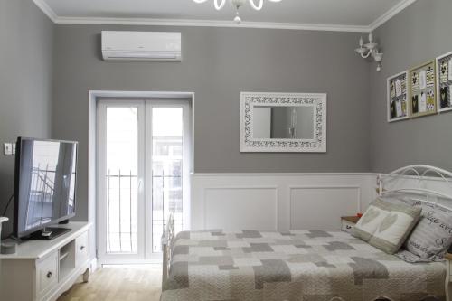 布加勒斯特布加勒斯特阿曼多公寓的一间卧室设有一张床、一台电视和一个窗口。