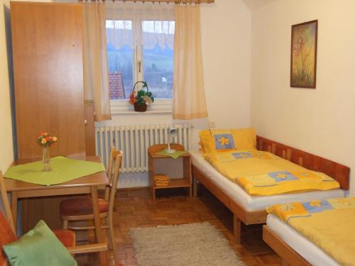 斯祖贝莱克Privat Ľubka的一间卧室设有两张床、一张桌子和一个窗口