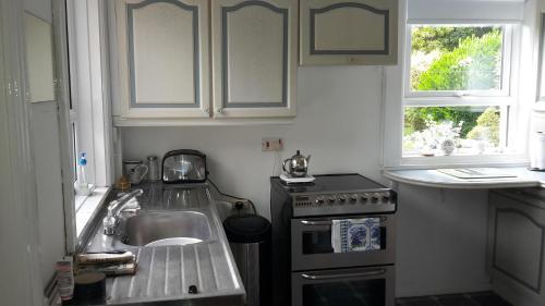 贝尔法斯特Hallmount House - Belfast的厨房配有水槽和炉灶