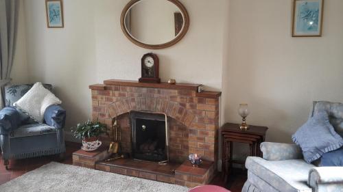 贝尔法斯特Hallmount House - Belfast的客厅设有砖砌壁炉和镜子