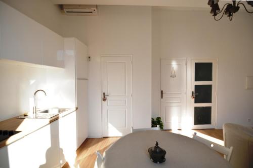 昂蒂布Hanna-Logis的白色的厨房配有桌子和水槽