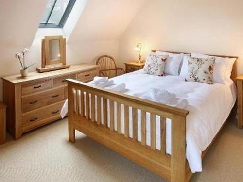 奇平卡姆登Boddingtons Barn @ Norton Grounds的一间卧室配有一张床、一个梳妆台和一扇窗户。
