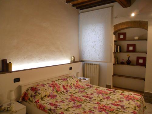 比森齐奥营Luigi Home的一间卧室配有一张带花卉床罩的床