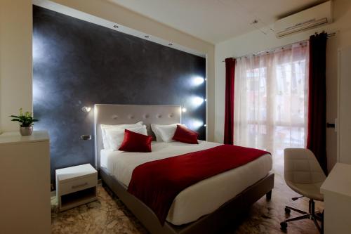 罗马罗马梵蒂冈套房旅馆的一间卧室配有一张带红色枕头的大床