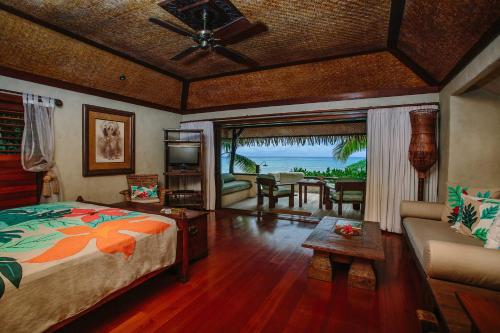 阿鲁坦加Pacific Resort Aitutaki - Adults Only的一间卧室设有一张床和一间客厅。