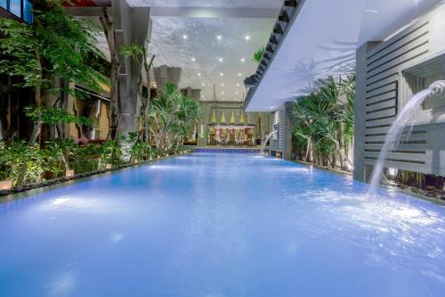 暹粒金庙精品酒店的一座带喷泉的建筑里的大型游泳池