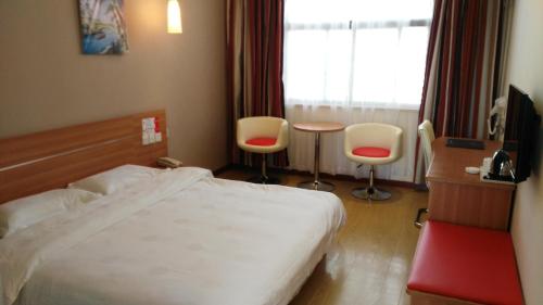 信阳尚客优连锁河南信阳火车站工区路店的酒店客房带一张床、一张桌子和椅子