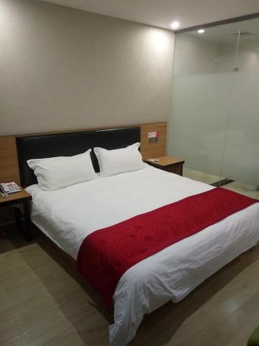 Wujiayao尚客优连锁江苏泰州泰兴市星火路店的一间卧室配有一张带红色毯子的大床