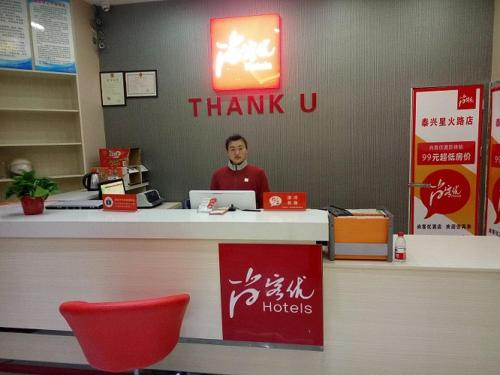 Wujiayao尚客优连锁江苏泰州泰兴市星火路店的手提电脑站在柜台上的人