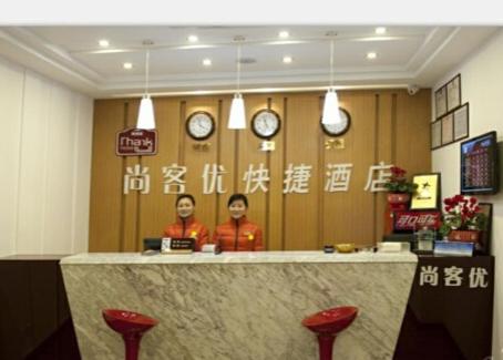 扬州尚客优连锁江苏扬州邵伯大运河店的两个人站在餐厅柜台后面