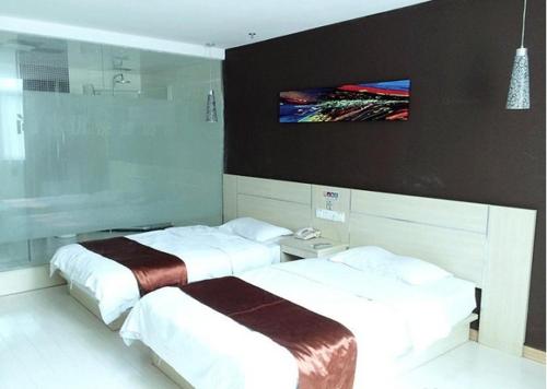 泰州尚客优连锁江苏姜堰步行街店的配有两张床铺的客房,墙上配有电视