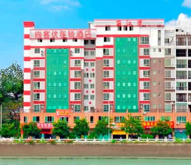 梅州尚客优连锁广东梅州梅县丽江湾店的一座大型建筑,旁边是红色和绿色的窗户