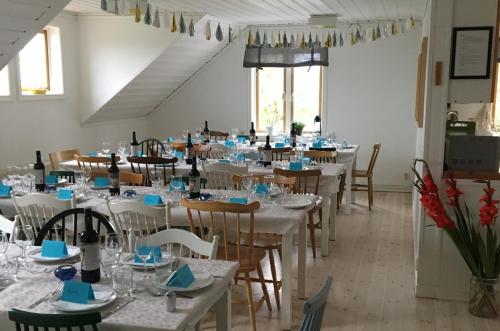 MöjaSTF Möja Vandrarhem的一间用餐室,配有白色的桌椅和蓝色的餐巾
