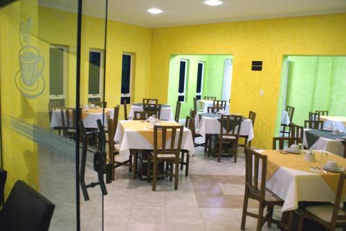 坎普拉古Hotel Manayara的用餐室设有桌椅和黄色的墙壁
