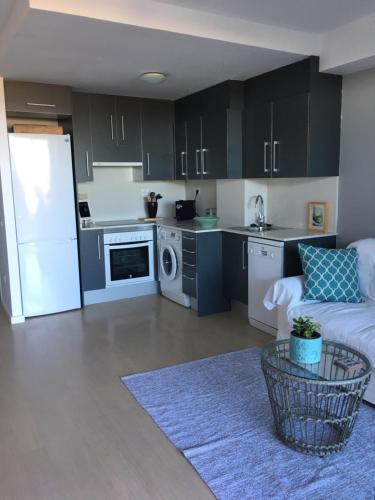 卡斯特尔德费尔斯Beach flat with garden的厨房配有黑色橱柜和白色冰箱。