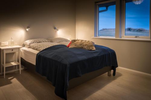 霍尔斯沃德吕尔Bryggjur的一间卧室配有一张带蓝色毯子的床