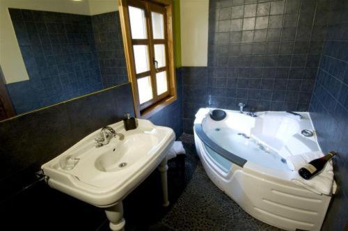 维多利亚-加斯特伊兹厄尔库托酒店及餐厅的浴室设有水槽和水槽旁的浴缸