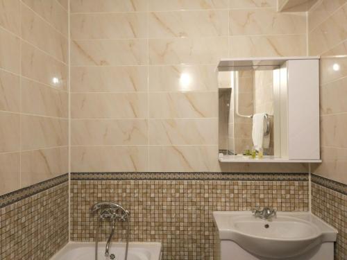 阿拉木图Loftik Apartments Abay street的浴室配有盥洗盆、镜子和浴缸