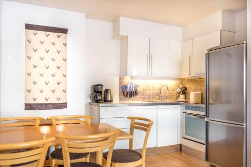 耶卢盖尔劳利亚公寓的厨房配有桌椅和冰箱。