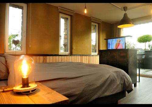 HamoisSur le tige hamois的一间卧室配有一张床和一张带台灯的桌子