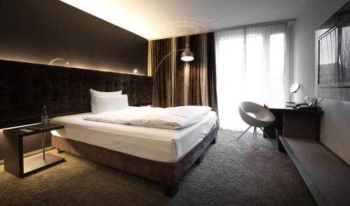 凯撒斯劳滕凯撒斯劳滕萨克斯城市设计酒店的酒店客房设有一张大床和一张书桌。
