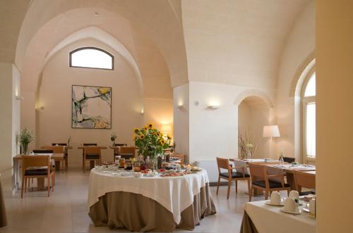 曼杜里亚科尔特鲍罗麦欧酒店的用餐室,配有鲜花桌