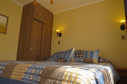 奥尔穆埃Cabañas Vikurayen的一间卧室配有一张带蓝白色毯子的床