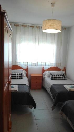 波尔托马林Apartamentos Loyo的一间卧室设有两张床和大窗户