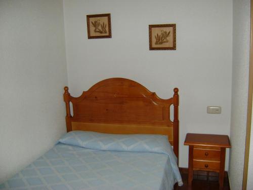 圣马尔廷德尔卡斯塔尼亚尔Casa Lopez的一间卧室配有一张带木制床头板和一张桌子的床。