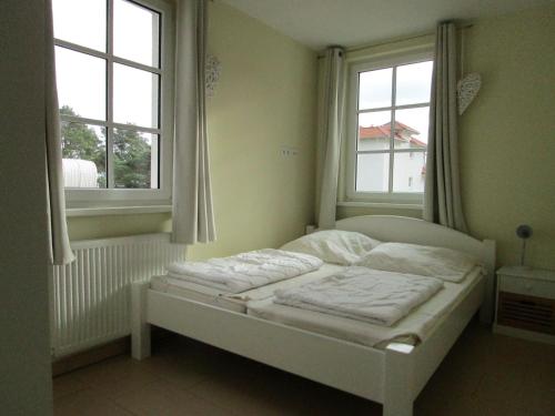 巴贝Haus Meeresblick Wohnung A 1.04的带2扇窗户的客房内的一张白色床