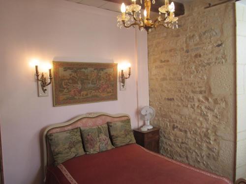Verteuil-sur-CharenteRue des Douves的一间卧室配有一张床,墙上挂着绘画作品