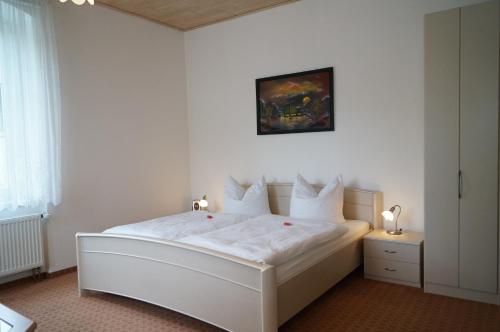 库罗阿尔滕堡Villa Angelika的卧室配有白色的床单和枕头