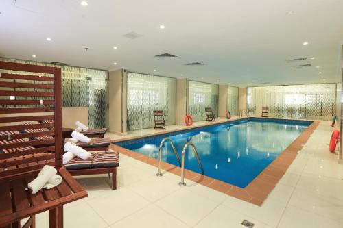吉达Prime Al Hamra Hotel的游泳池位于酒店带长凳的房间