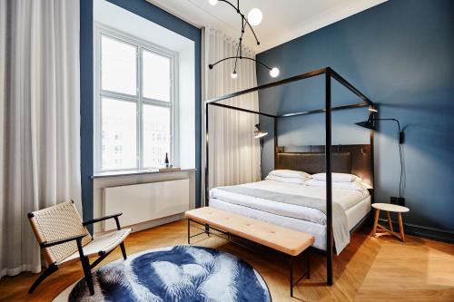 哥本哈根Nobis Hotel Copenhagen, a Member of Design Hotels™的卧室配有1张床、1张桌子和1把椅子
