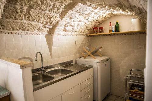 奥斯图尼Il Nido Bianco的一间带水槽和冰箱的小厨房