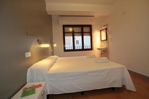 伊维萨镇伊维萨里波尔旅馆的卧室配有一张大白色床和窗户