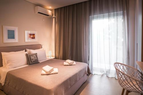 雅典雅典卫城下雅致房屋公寓的一间卧室配有一张床,上面有两条毛巾