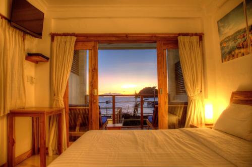纳闽巴霍蓝马林潜水科莫多民宿的一间卧室配有一张床,享有海景