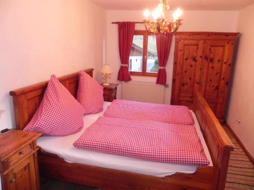 拉姆绍Haus am See的一间卧室配有红色和白色枕头的床