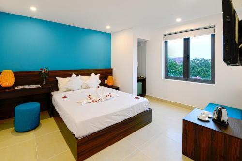 会安会安梦想城市酒店的一间卧室设有一张蓝色墙壁的大床