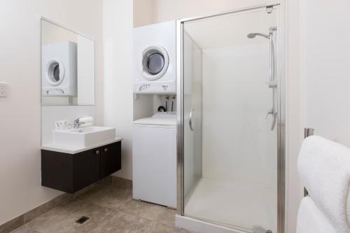 汉密尔顿切斯特汉密尔顿公寓式酒店的带淋浴、盥洗盆和洗衣机的浴室