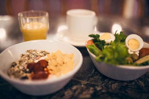 赫尔辛基安娜酒店的一张桌子,上面放着两碗食物和一杯橙汁