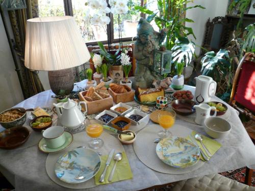 鲁西永阿姆喜酒店的一张带早餐食品的桌子和一盏灯