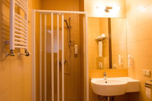 梅什库夫库库巴拉保龄球中心酒店的浴室配有盥洗盆、淋浴和盥洗盆。