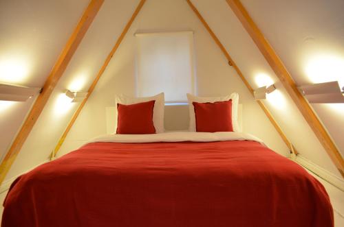 阿姆斯特丹Rembrandtplein Bed & Breakfast的客房内的一张红色床和两个枕头
