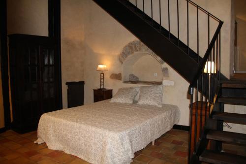 里昂圣约斯特拉特利尔旅馆的一间卧室设有一张床,卧室内有楼梯