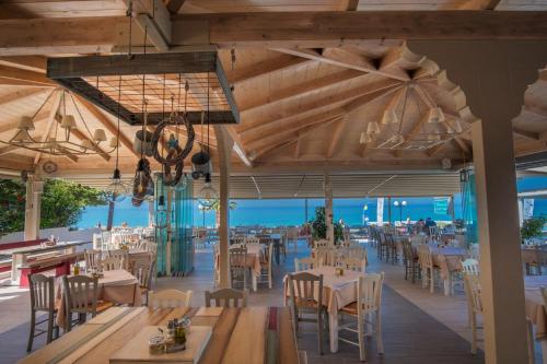 帕拉利亚维拉乔WhiteSands Beach Resort的一间带桌椅的海景餐厅