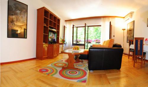 弗尔尼亚奇卡矿泉镇Apartman Lili的客厅配有沙发和一张桌子,铺在地毯上