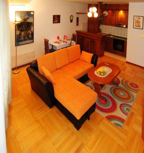 弗尔尼亚奇卡矿泉镇Apartman Lili的客厅配有橙色沙发和桌子