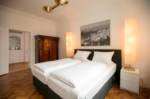 雷根斯堡Palazzo am Dom的一间卧室配有一张带白色床单的大床